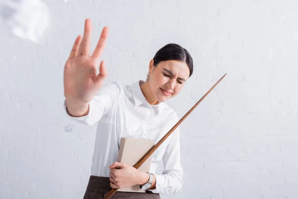 Lehrer mit Zeiger und Buch zeigt Stop-Geste in der Nähe zerknüllten Papiers — Stockfoto