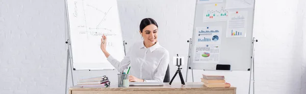 Smiling businesswoman pointing at flipchart while having video call, banner — Stock Photo