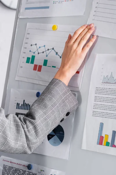 Vista recortada de la mujer de negocios de pie cerca del rotafolio con gráficos - foto de stock