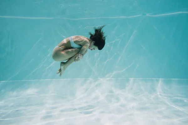Brunetta giovane donna in costume da bagno bianco nuotare in piscina — Foto stock