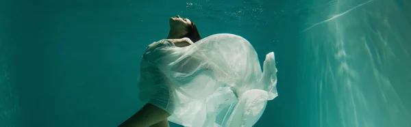 Mujer joven pacífica en vestido elegante blanco nadando en la piscina, pancarta - foto de stock