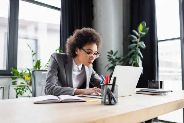 Gerente afroamericano usando portátil en la oficina - foto de stock