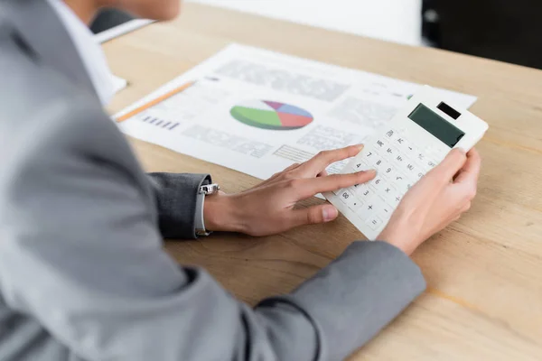 Vista cortada de empresária usando calculadora perto de papel embaçado na mesa — Fotografia de Stock