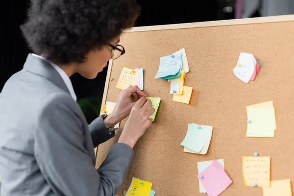 Femme d'affaires afro-américaine travaillant avec des notes collantes au bureau — Photo de stock