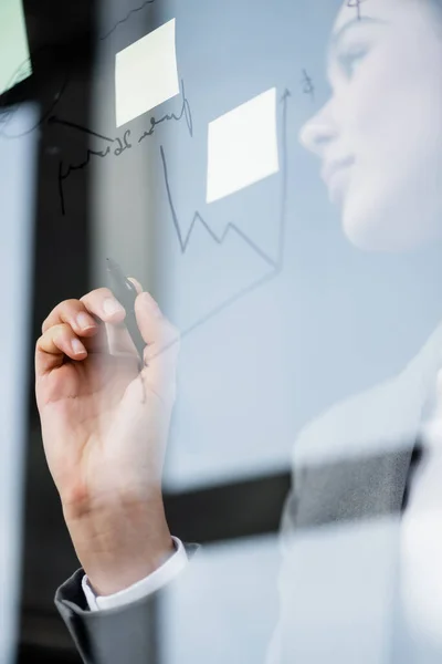 Vista de ángulo bajo de carta y notas adhesivas en tablero de vidrio cerca de la mujer de negocios afroamericana — Stock Photo