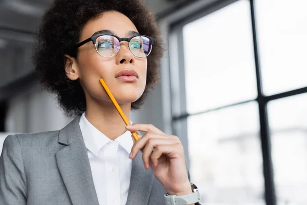 Low angle view of african american manager with pencil looking away — Stock Photo