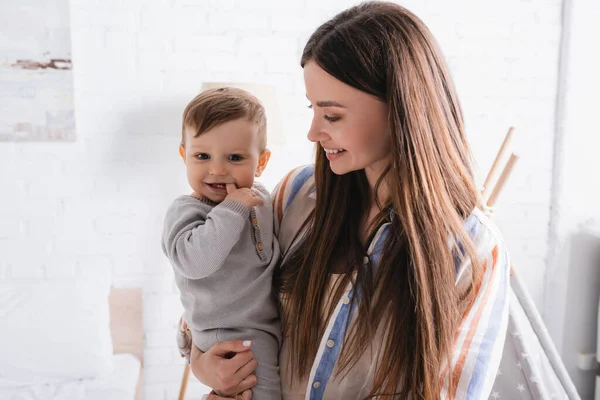 Весела мати тримає в руках немовля сина — стокове фото