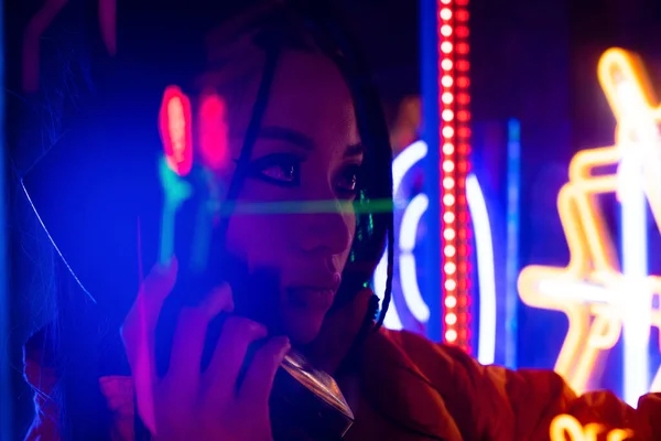 Neon lighting near young asian woman talking on retro telephone — Fotografia de Stock