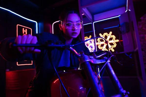 Young asian woman in sunglasses riding motorcycle outside — Stock Photo