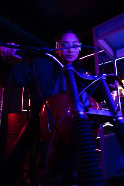 Young asian woman in sunglasses riding blurred motorcycle — Photo de stock