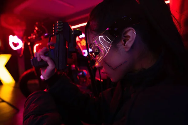 Armed asian woman with artificial scar holding gun outside - foto de stock