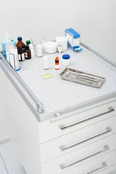 High angle view of dental tools in metal tray and medicines on table in clinic — Stock Photo