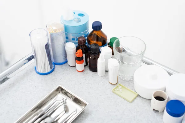 High angle view of medicines and clean stainless dental tools in tray on medical table — Stock Photo