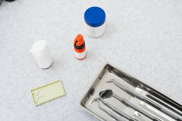 Vue de dessus des outils dentaires dans un plateau en métal sur une table médicale — Photo de stock