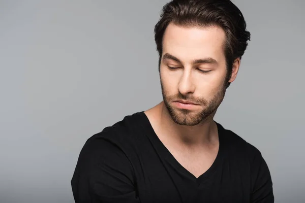 Good-looking man in black t-shirt looking away isolated on gray — Stock Photo