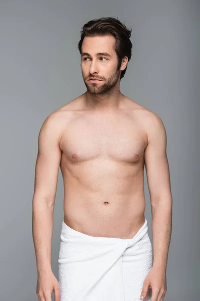 Young muscular man in towel looking away isolated on grey — Stock Photo