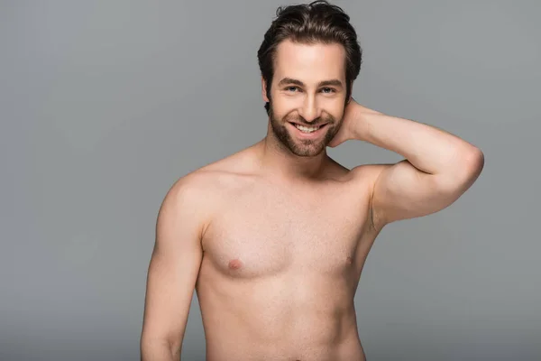 Good-looking shirtless man smiling and looking at camera isolated on grey — Stock Photo