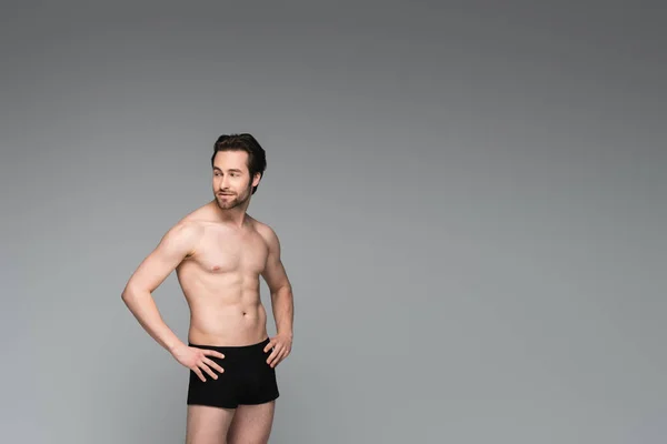 Shirtless man in black underwear posing with hands on hips isolated on grey — Stock Photo