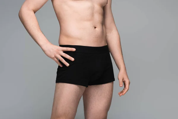 Обрезанный вид человека без рубашки в черном нижнем белье, позирующего изолированно на сером — стоковое фото