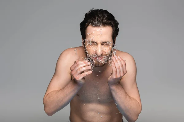 Jovem barbudo com olhos fechados lavar rosto isolado em cinza — Fotografia de Stock
