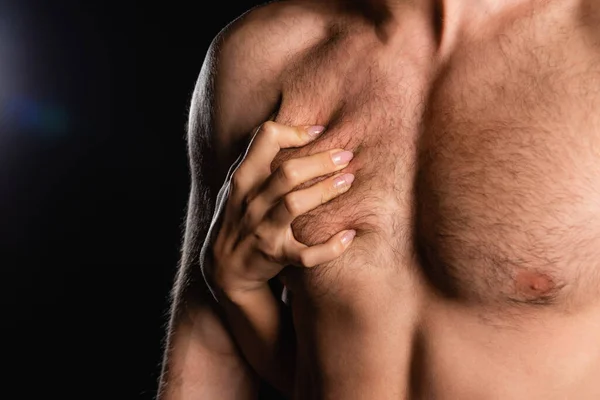 Close up tiro de mão feminina apaixonadamente tocando o homem com tronco sem camisa no fundo preto — Fotografia de Stock