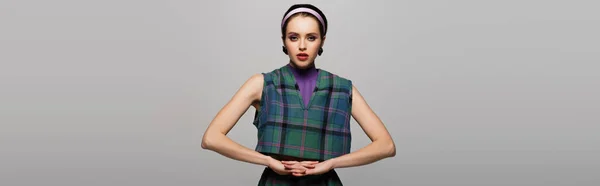 Young model in headband and earrings posing isolated on grey, banner — Stock Photo