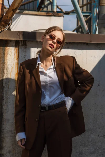 Stylisches junges Model im braunen Anzug posiert mit der Hand an der Hüfte — Stockfoto