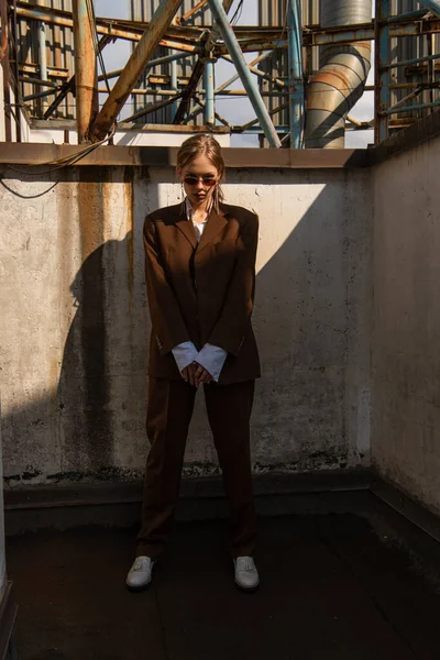 Blondes junges Model im braunen Anzug posiert auf dem Dach — Stockfoto