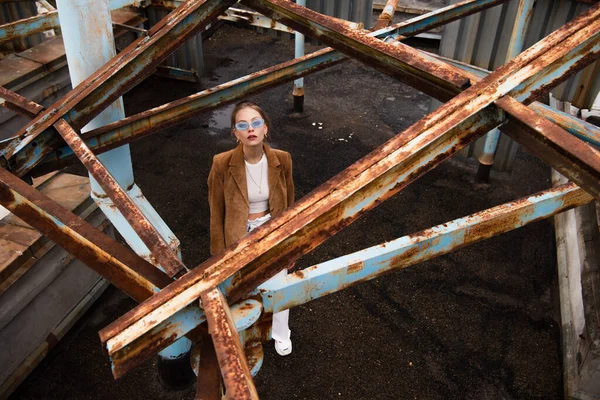 Vista de ángulo alto de la mujer bonita en traje elegante y gafas de sol de pie en la azotea - foto de stock