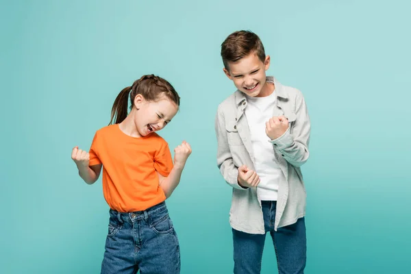 Enfants excités avec les yeux fermés se réjouissant isolé sur bleu — Photo de stock