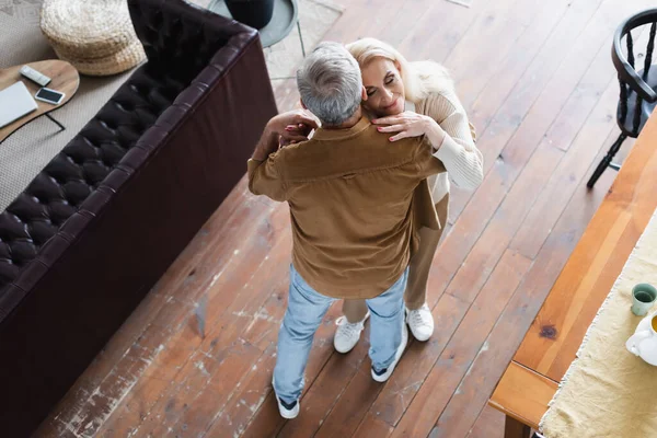 Vista aérea de la mujer con los ojos cerrados bailando con el marido - foto de stock