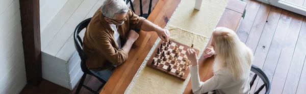 Vue aérienne du couple de personnes âgées jouant aux échecs à table, bannière — Photo de stock