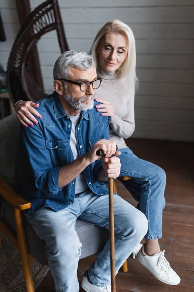 Blurred woman calming husband with crutch — Stock Photo