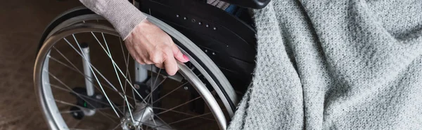 Cropped view of elderly woman with blanket holding wheel of wheelchair, banner — Stock Photo