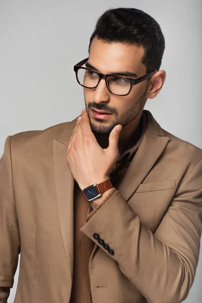 Hombre de negocios árabe en ropa formal marrón aislado en gris - foto de stock