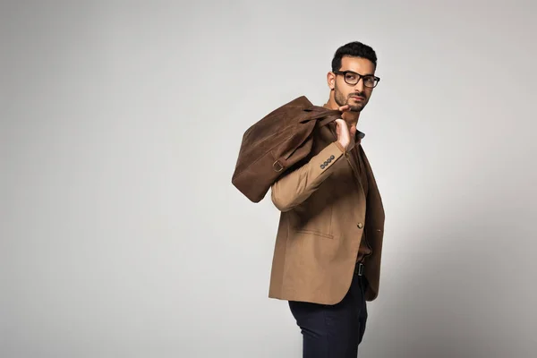 Homme d'affaires musulman tenant sac à main brun isolé sur gris — Photo de stock