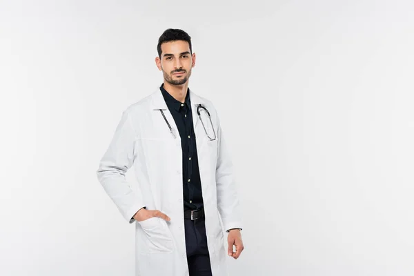 Muslim doctor holding hand in pocket of white coat isolated on grey — Stock Photo