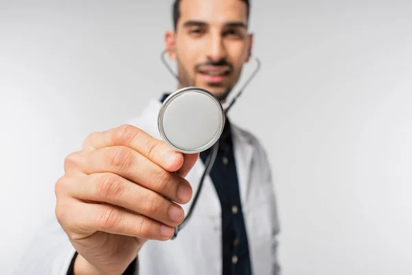 Stéthoscope en main d'un médecin musulman flou isolé sur fond gris — Photo de stock
