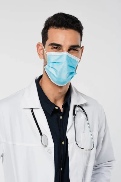 Arabian doctor with stethoscope looking at camera isolated on grey — Stock Photo