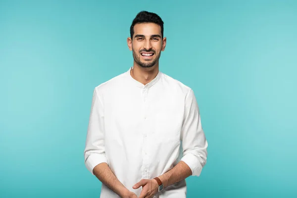 Arabe homme en chemise blanche souriant à la caméra isolé sur bleu — Photo de stock