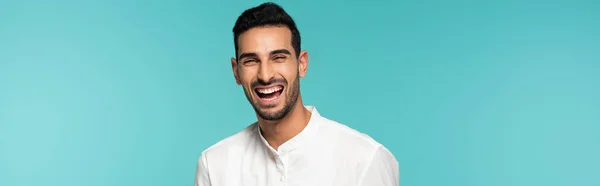 Happy arabian man looking at camera isolated on blue, banner — Stock Photo