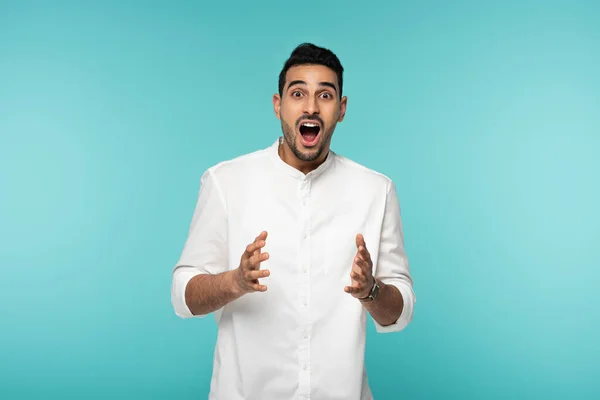 Excited muslim man in white shirt isolated on blue — Stock Photo