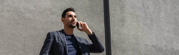 Jeune homme d'affaires musulman parlant sur téléphone portable à l'extérieur, bannière — Photo de stock