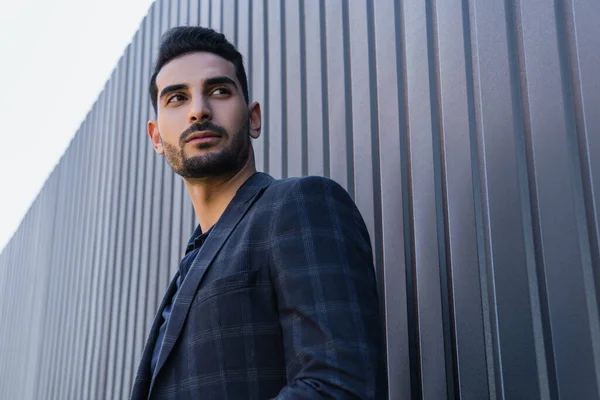 Niedriger Blickwinkel auf junge muslimische Geschäftsleute, die in der Nähe von Zaun wegschauen — Stockfoto