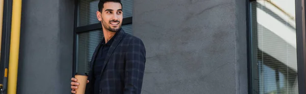 Smiling muslim businessman holding coffee to go outdoors, banner — Stock Photo