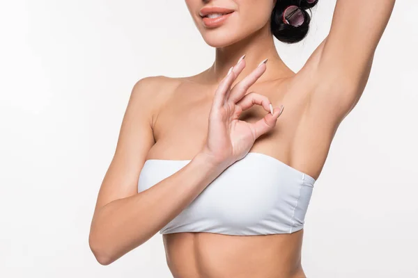 Partial view of young woman showing smooth armpit with okay gesturing with hand isolated on white — Stock Photo