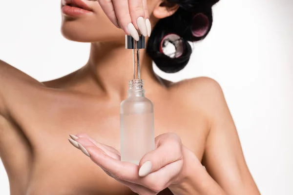 Partial view of young woman holding serum bottle and pipette in hands isolated on white — Stock Photo