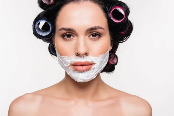 Портрет серйозної молодої жінки з кремом для гоління на обличчі ізольовано на білому — стокове фото