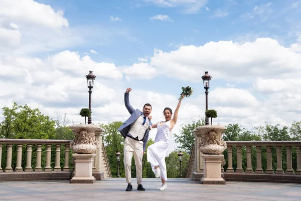 Noivo alegre mostrando sim gesto perto da noiva no parque — Fotografia de Stock