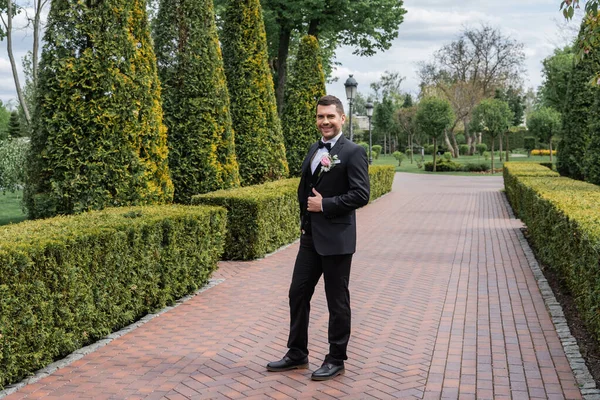 Alegre novio mostrando como gesto en parque - foto de stock